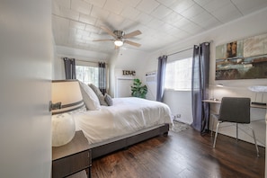 Cozy retreat with a large bed, side table, and desk for a comfortable stay.