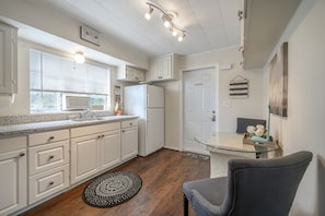 Kitchen features a refrigerator, microwave, and sink with a faucet.