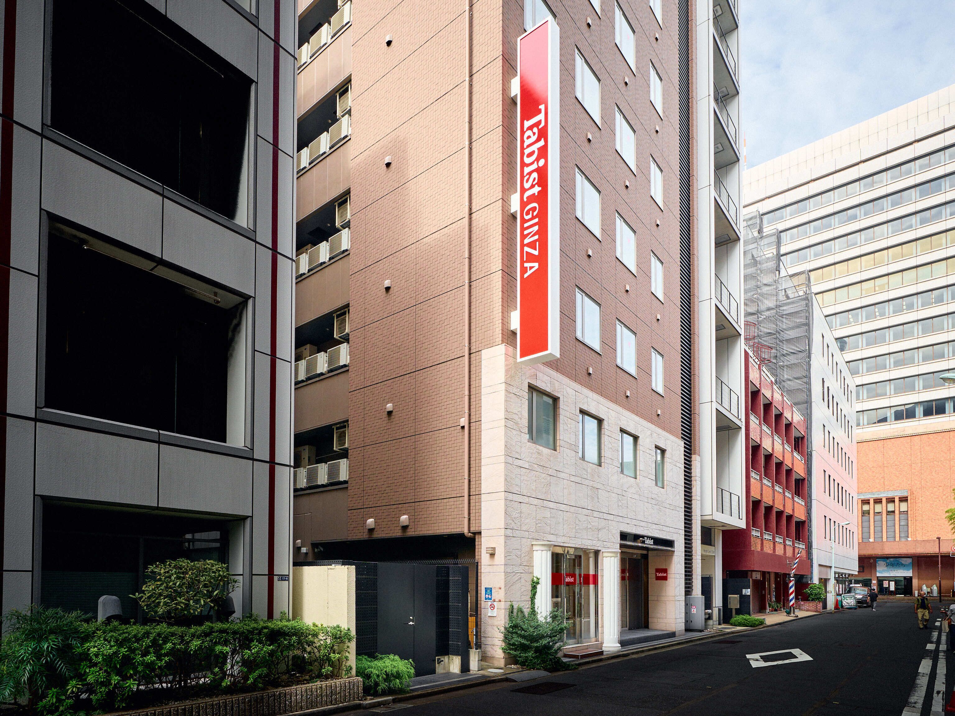 A modern building with a prominent red sign reading "Tabist GIZA".