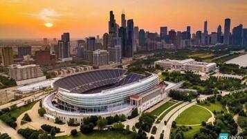 A stadium surrounded by modern buildings and a river.