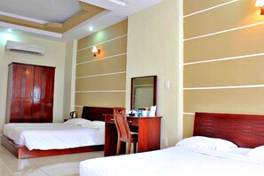 A hotel room with two beds, a wooden desk, a mirror, and a wardrobe. - S79 Residences Yaya Bui Vien (Ho Chi Minh City)
