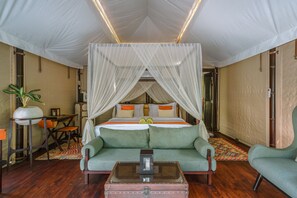 A room with a four-poster bed, a green sofa, a small table, and a potted plant. - Kanva Ubud (Tegallalang)