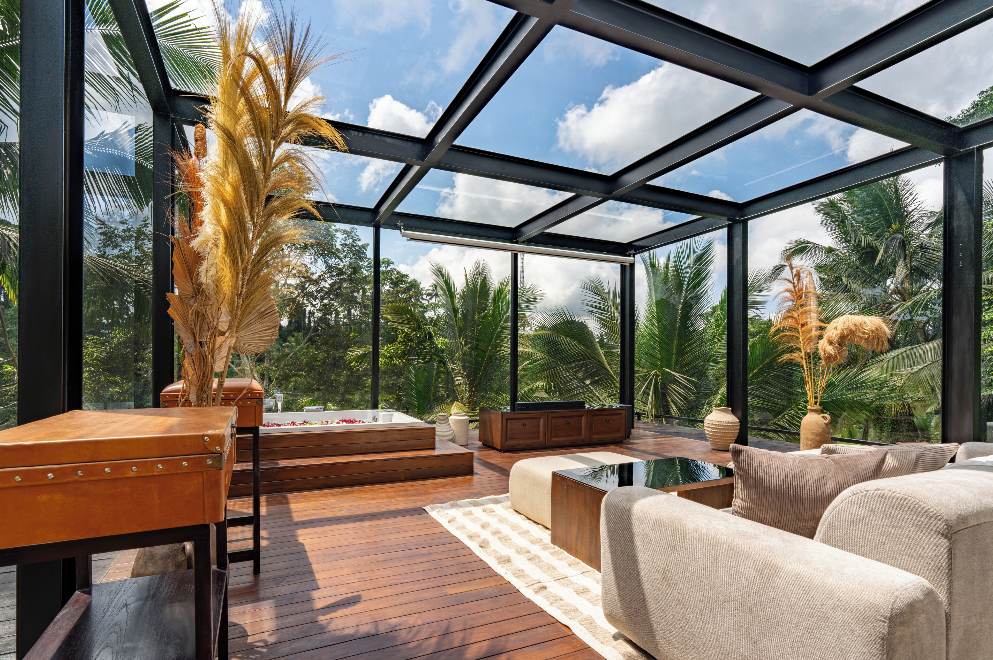 A modern interior with a glass ceiling, wooden flooring, a sofa, a coffee table, and a fireplace.