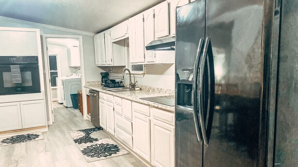 A kitchen with white cabinets, a stainless steel refrigerator, a dishwasher, and a microwave. - Scenic Mountain Views 4 Bed 2 Bath (Cave Spring)