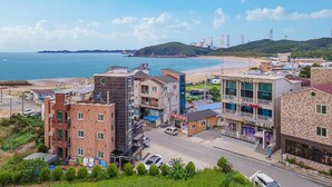 A coastal town with buildings, a beach, and a view of the sea. - Taean Happyzonepension (Taean)