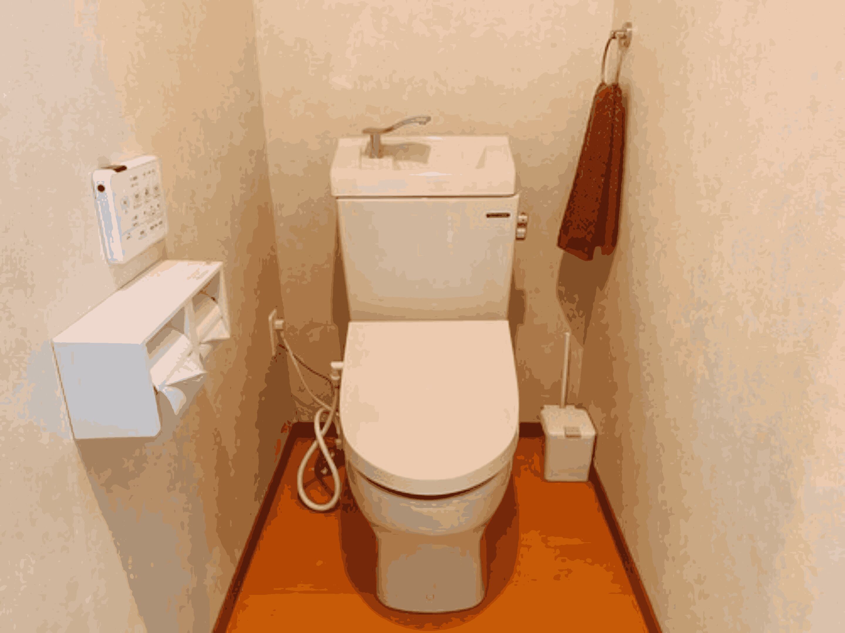 Une petite salle de bain avec des toilettes, un lavabo et une serviette accrochée au mur.