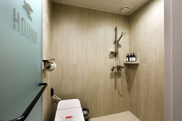 A bathroom with a shower, toilet, and hand sanitizer on a shelf. - Hound Hotel Incheon Airport (Incheon)