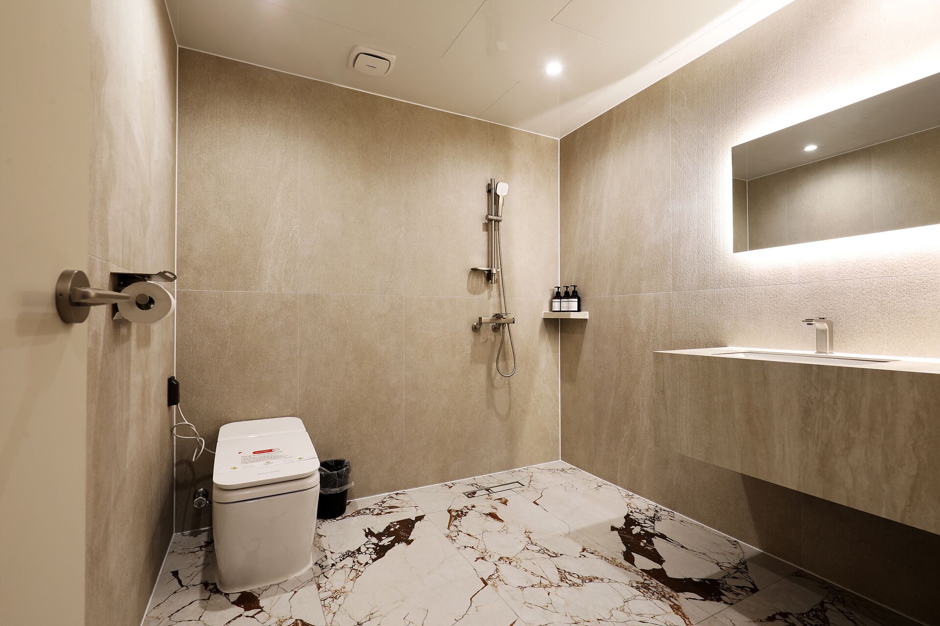 A modern bathroom with a walk-in shower, a toilet, and a vanity with a mirror.