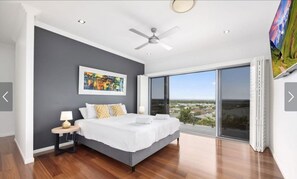 Wake up to sweeping views from the master bedroom — polished timber floors, a king bed, and floor-to-ceiling sliding doors to the balcony. - Sandy View - 180 degree views - Luxury Home (Nikenbah)