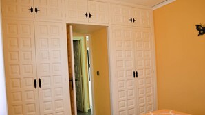 A bedroom with a bed, a wardrobe with multiple doors, and a butterfly wall decoration. - Beautiful oasis with pool landscape near the dream beach Las Marinas (Dénia)