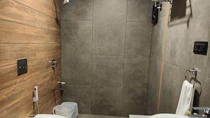 A modern bathroom with a wooden vanity, a freestanding toilet, and a large sink. - Nirvana Resort and Restaurant (Garudeshwar)