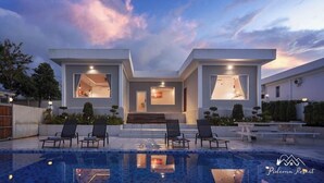 Una casa moderna con piscina, dos habitaciones visibles con ventanas amplias y mobiliario exterior.