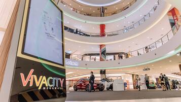 Um grande shopping com vários níveis e um amplo átrio central, com uma placa chamativa indicando 'VivaCity Megamall'.