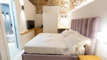 Una camera da letto con un letto, un comodino e una televisione.
