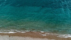 Una playa con agua turquesa cristalina y una orilla arenosa.