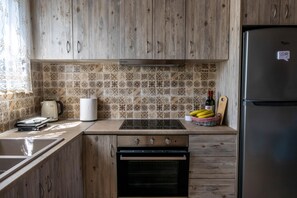 A kitchen with wooden cabinets, a tiled backsplash, a stove, a sink, and a refrigerator.