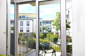 A balcony with a view of neighboring buildings and a small garden area. - Boardinghouse Henschelstraße (Munich)
