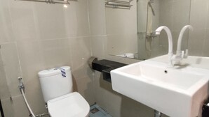 A modern bathroom with a toilet, sink, and shower. - Golden Ganesha Hotel Yogyakarta by Ecommerceloka (Banguntapan)