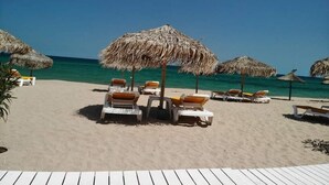 A beach with thatched umbrellas and lounge chairs. - Apartamente 2 Tomis Villa (Navodari)
