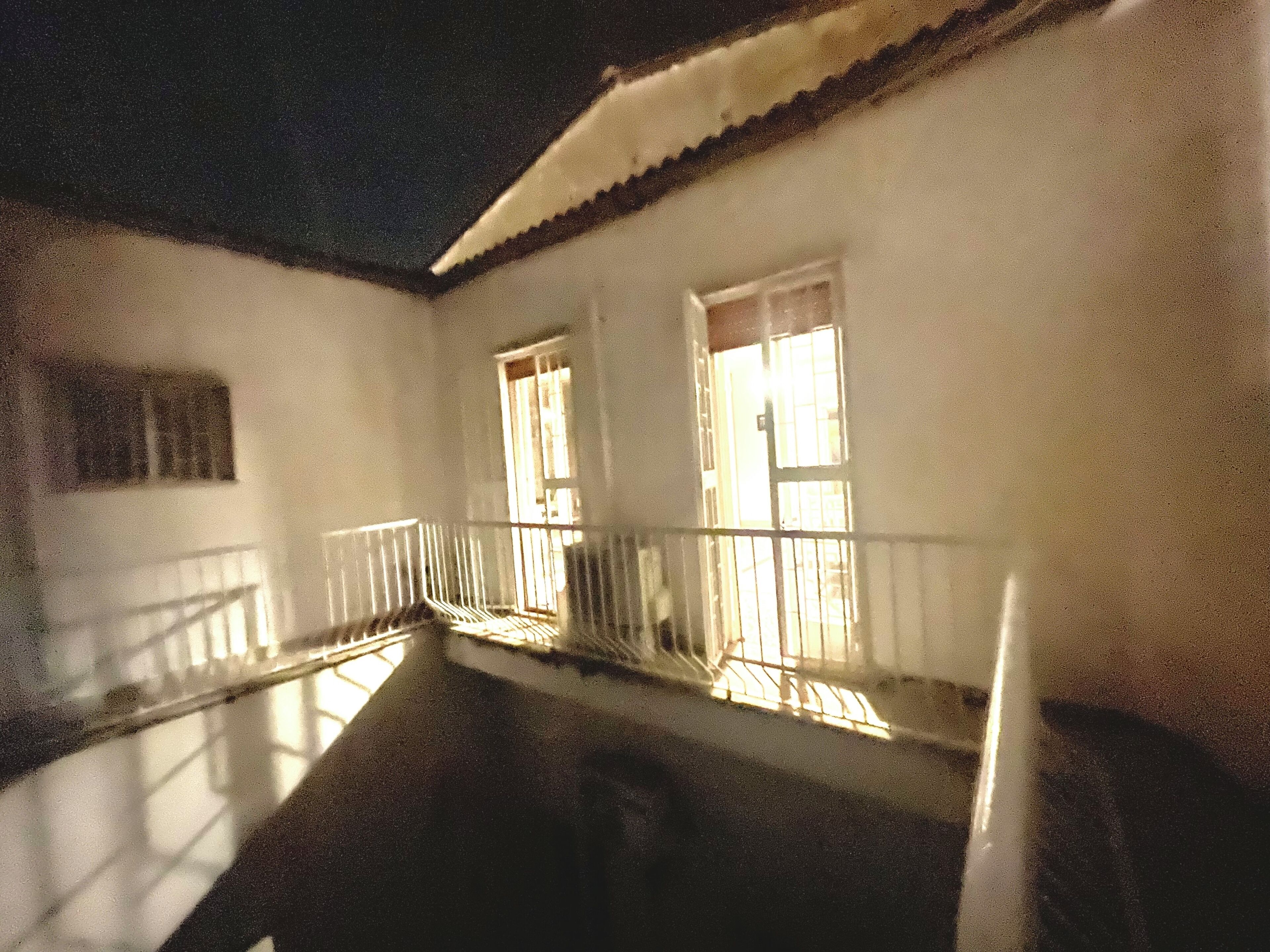Un edificio con dos ventanas, un balcón y una escalera.