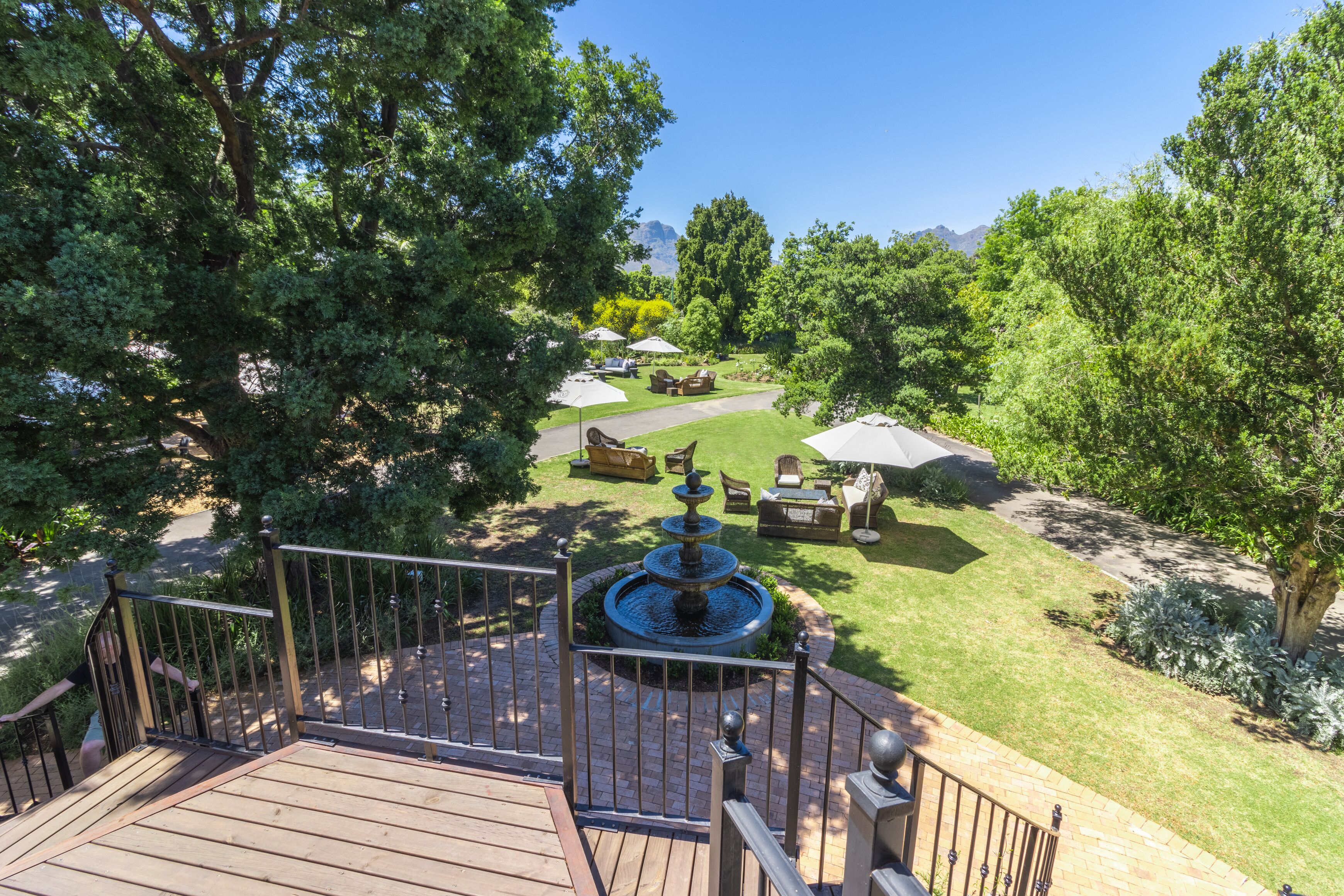 A deck with a fountain, surrounded by a well-maintained lawn and outdoor furniture.