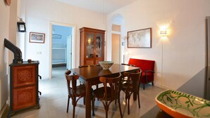 Un comedor con mesa y sillas de madera, una silla roja, un armario y un mapa en la pared.