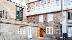 A stone building with a balcony, a door, and a sign reading "Avenida de Faxoi". -  Hotel Plaza Obradoiro by Bossh! Hotels (Santiago de Compostela)