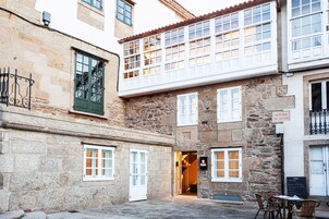 Un edificio de piedra con un balcón, una puerta y un letrero que dice "Avenida de Faxoi".