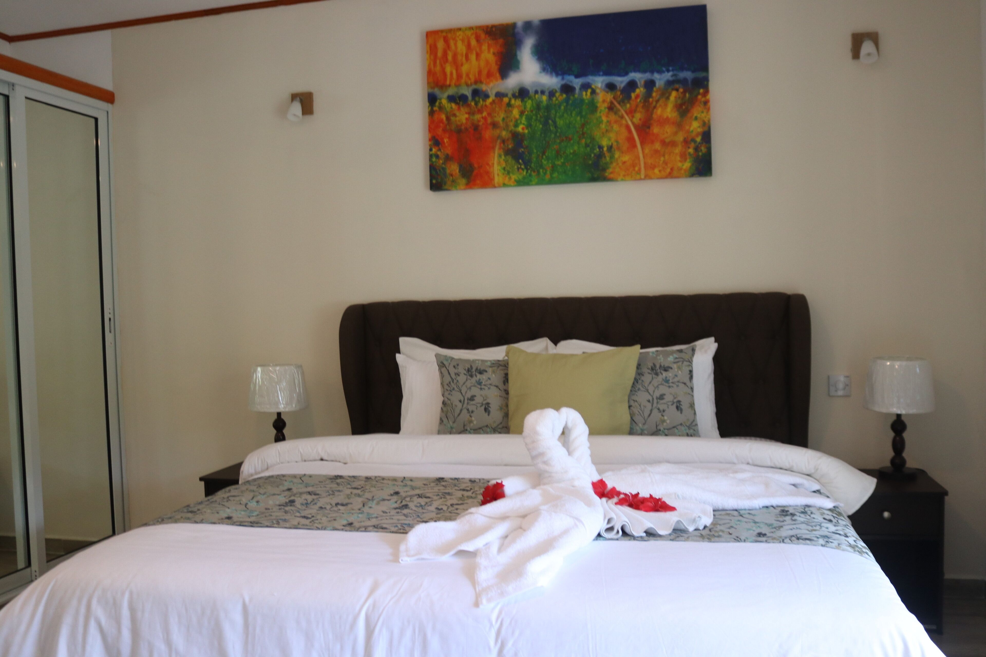 A neatly made bed with a white comforter and a decorative towel arrangement.