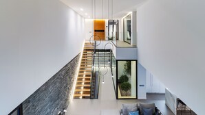 Ein modernes Interieur mit einer Treppe, die zu einer zweiten Etage führt, einem Essbereich und einer Küche.