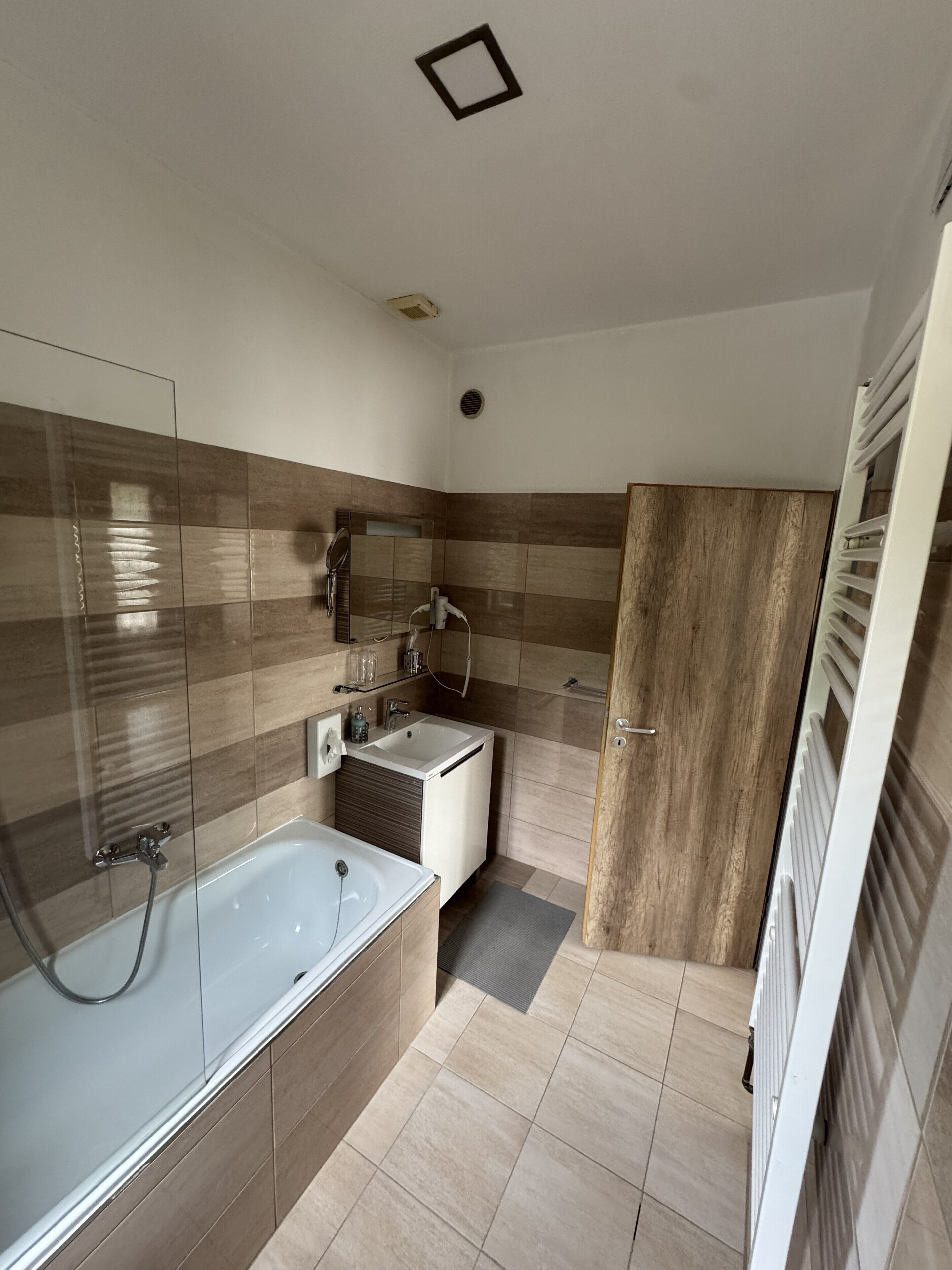 A modern bathroom with a bathtub, a sink, and a shower area.