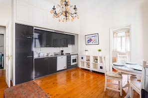 Enjoy meals in the kitchen and dining area with stainless steel appliances, white cabinetry, and a round table.
