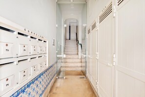Guests can access secure lockers and a staircase with handrail in this well-maintained corridor.