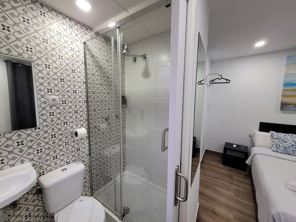 Une salle de bain moderne équipée d’une douche, de toilettes et d’un lavabo.
