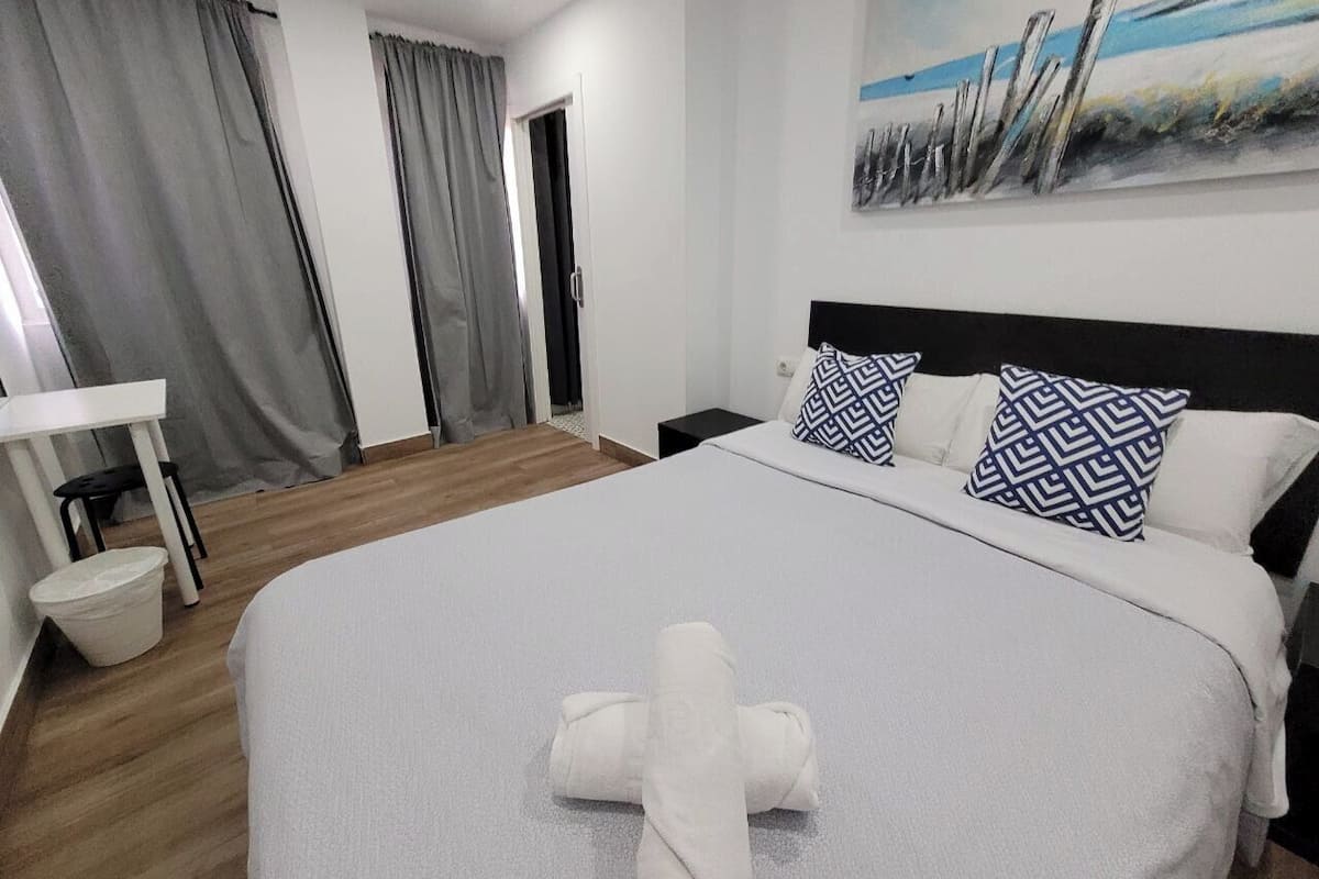 Une chambre d’hôtel avec un grand lit, un bureau et un tableau au mur.