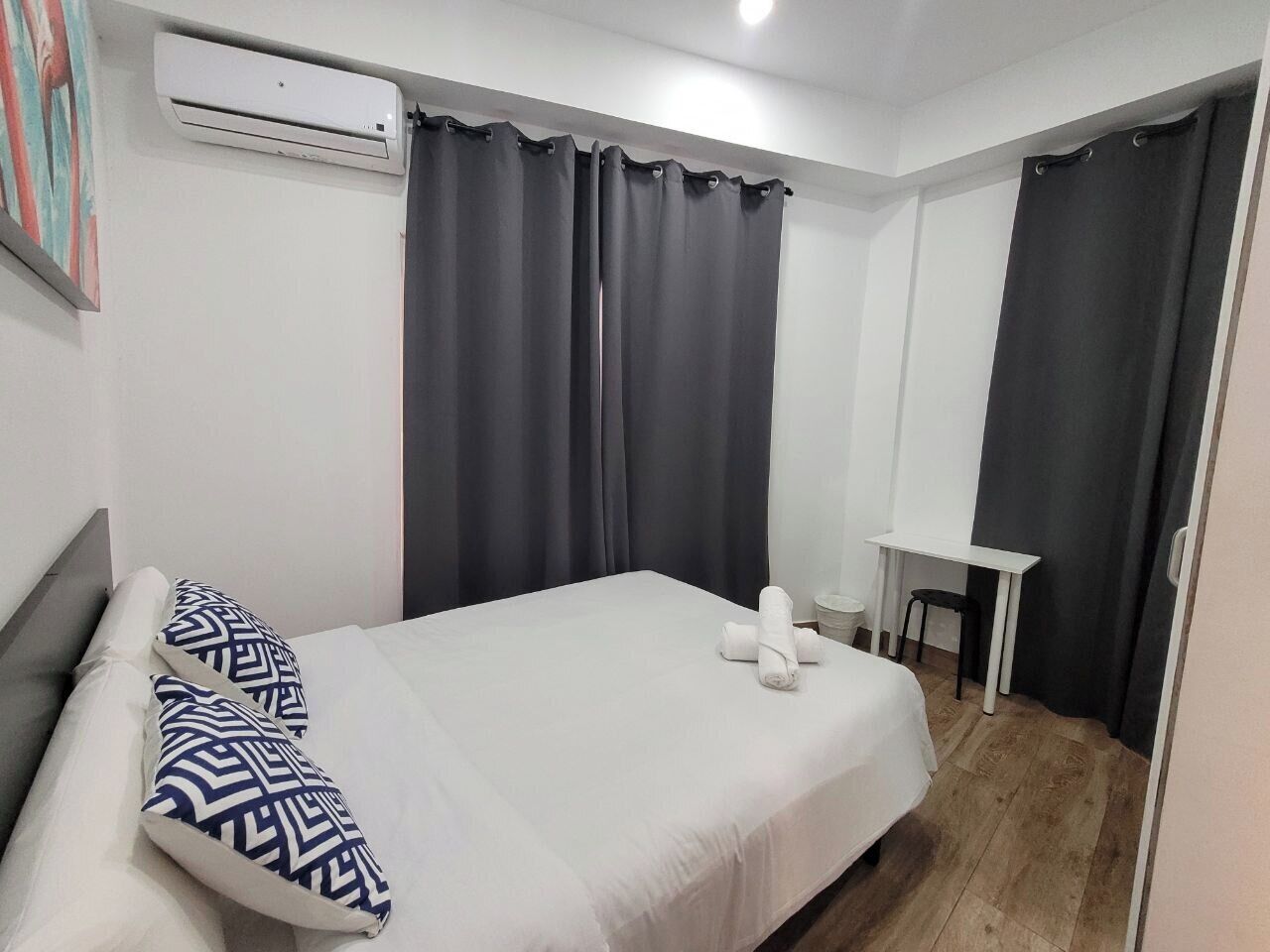 Habitació d'hotel amb un llit, una taula de treball i una cadira.