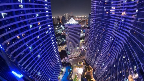 A high-rise building with a distinctive pyramid-shaped top, surrounded by other tall buildings. - One Bedroom Balcony With Great Location and Value (Makati)
