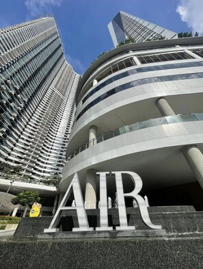 A modern building with a curved facade and the letters "AIR" prominently displayed. - One Bedroom Balcony With Great Location and Value (Makati)