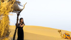 A desert landscape with sand dunes and a camel. - Marvin Desert Camp (Jaisalmer)