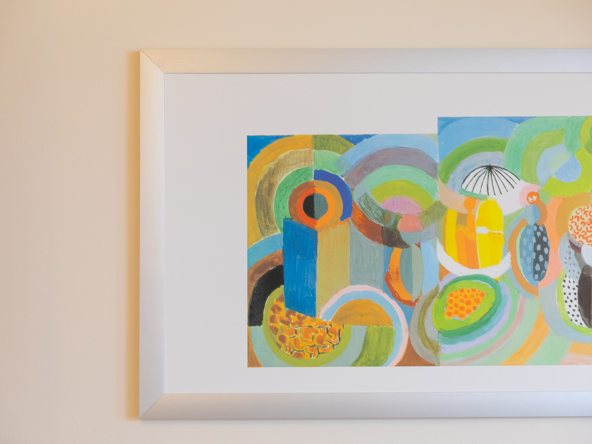 Une peinture abstraite encadrée, aux couleurs vives et aux motifs circulaires.