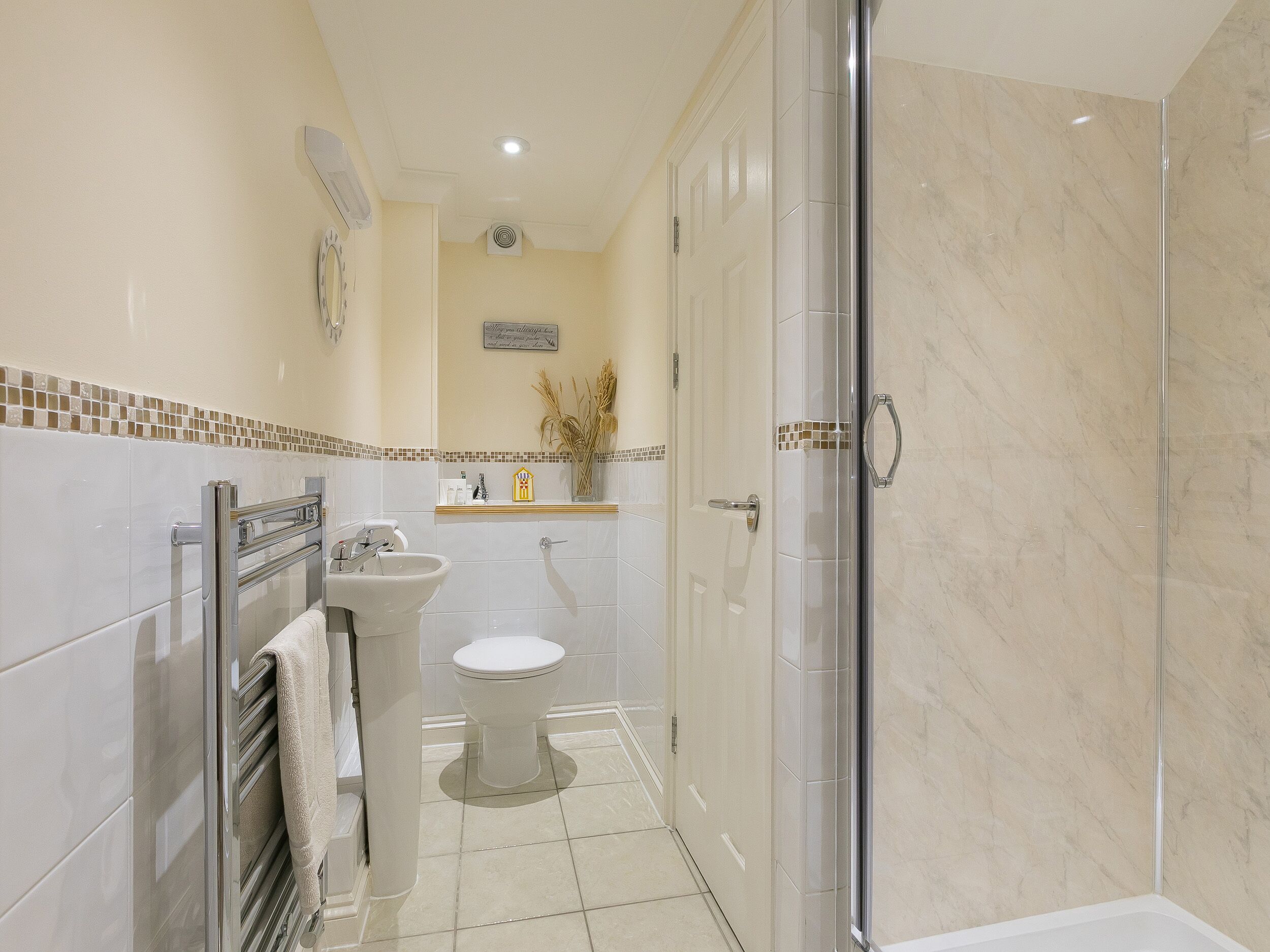 Un bagno moderno con box doccia in vetro, lavandino e WC.