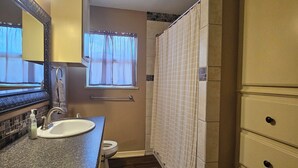 Ein kleines Badezimmer mit Waschbecken, Toilette und Dusche.