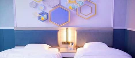 A hotel room with two beds, a wall-mounted light, and decorative hexagonal wall art.