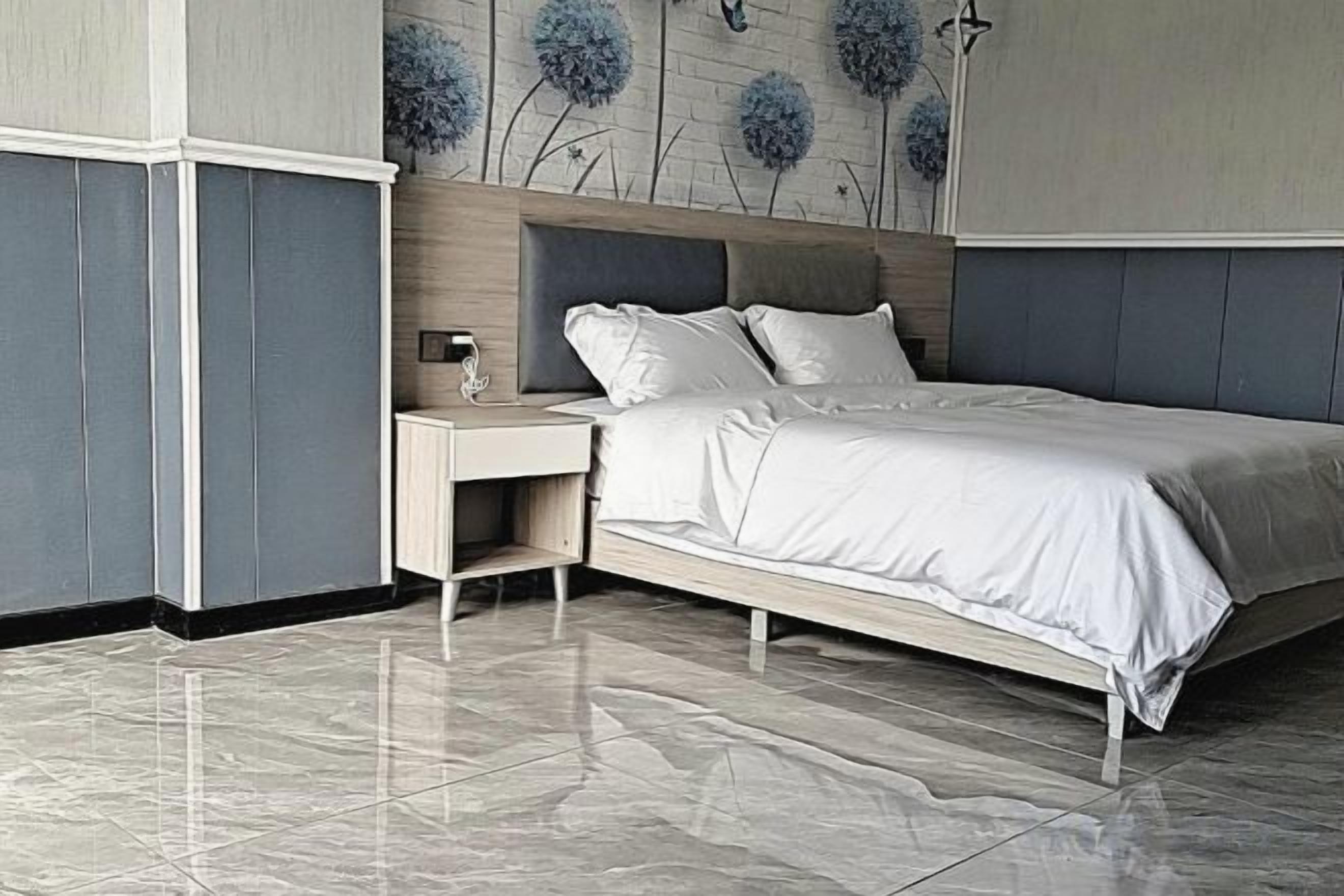 Un dormitorio con cama, mesita de noche y lámpara de pared.