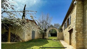 A courtyard with stone buildings, an archway, and blooming trees. - Typical house with dovecote, swimming pool, summer kitchen, close to vineyards (Courrech, GREZELS)