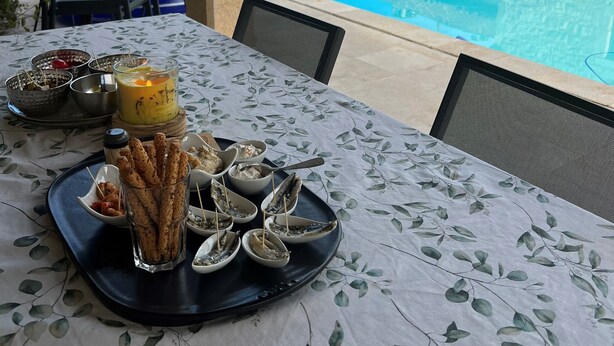 A table set with snacks and a candle, overlooking a swimming pool and a stone building. - Typical house with dovecote, swimming pool, summer kitchen, close to vineyards (Courrech, GREZELS)