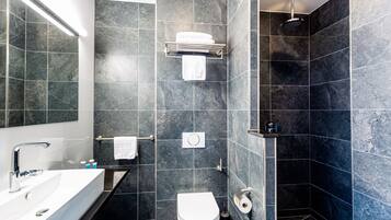Un bagno moderno con un lavandino bianco, un WC e uno spazio doccia.