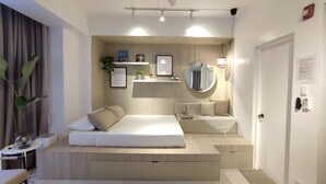Een moderne slaapkamer met een inbouwbed, nachtkastjes, een spiegel en een plank met decoratieve objecten.