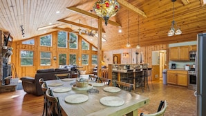 Una cabaña de madera espaciosa con un amplio comedor, cocina y sala de estar.