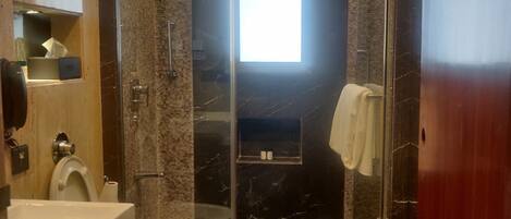 Un baño moderno con cabina de ducha de vidrio, inodoro y lavamanos.